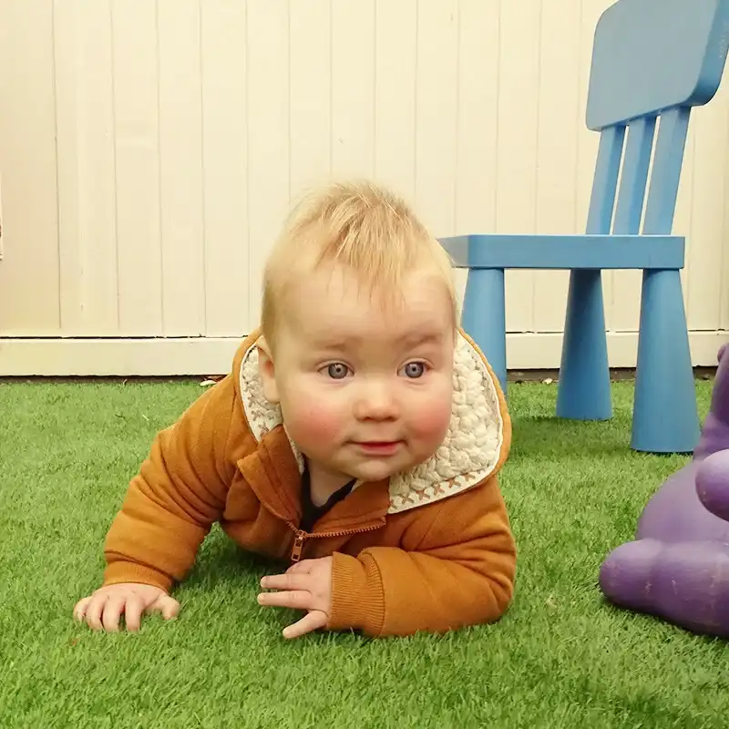 kruipende-baby-gras-buitenspelen-ark-oss » Kinderopvang & BSO in Oss Een baby kruipt ontdekkend door het gras in de tuin van Kindercentrum de Ark in Oss.